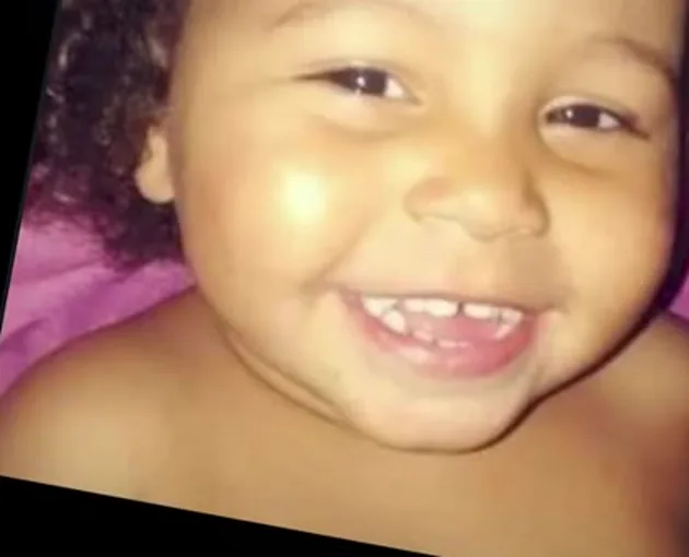 Ana Clara bem pequena, sorrindo de perto para a câmera.